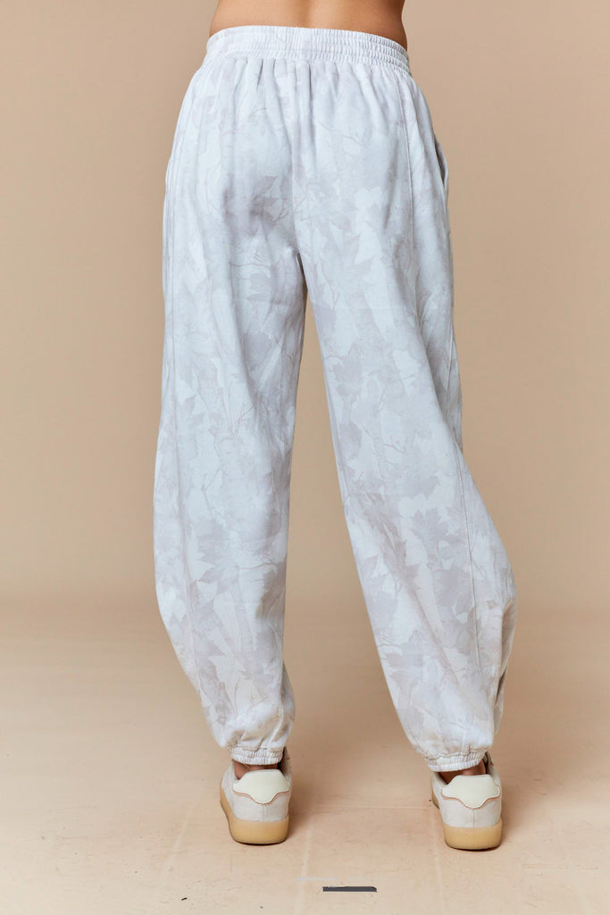 White and pale gray tonal leaf print jogger pants with elastic waist and cuffs, casual boutique loungewear.