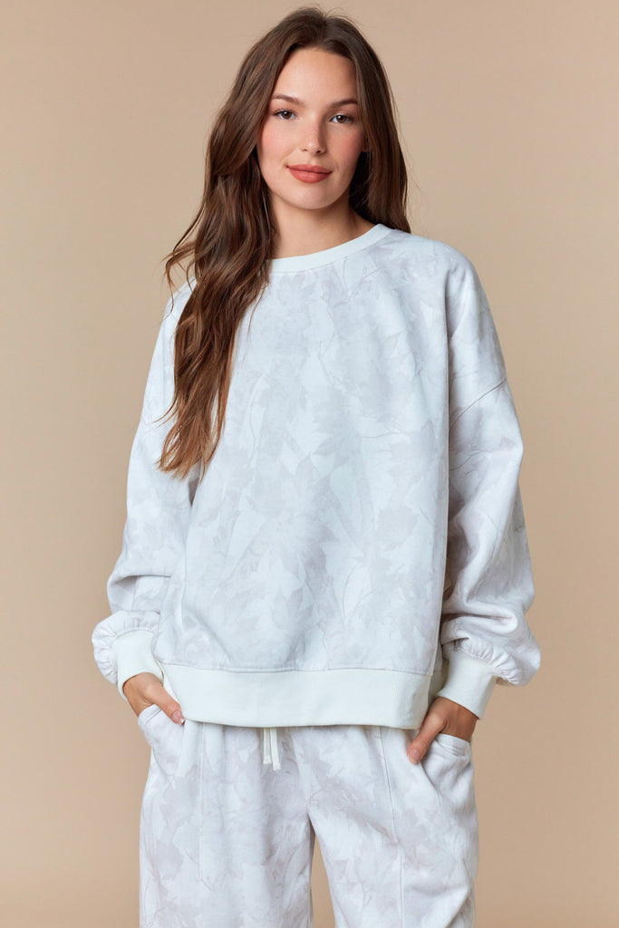 Neutral oversized pullover sweatshirt with tonal leaf print and ribbed trim.