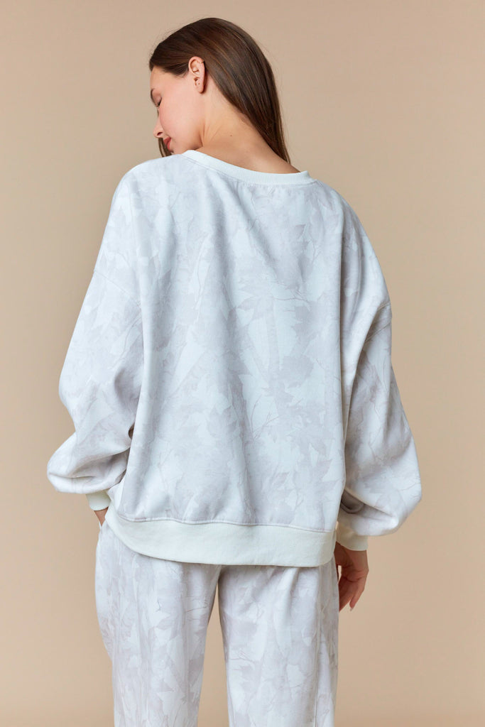 Neutral oversized pullover sweatshirt with tonal leaf print and ribbed trim.