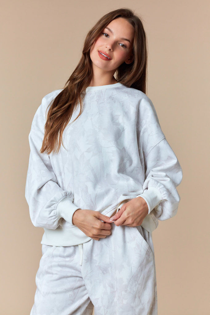 Neutral oversized pullover sweatshirt with tonal leaf print and ribbed trim.