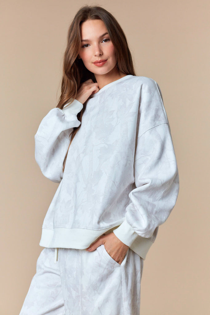 Neutral oversized pullover sweatshirt with tonal leaf print and ribbed trim.