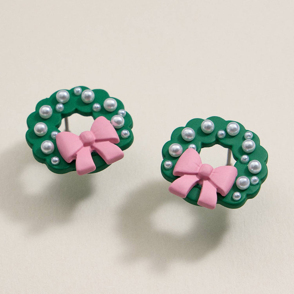 Green enamel Christmas wreath stud earrings with pearl accents and pink bows.