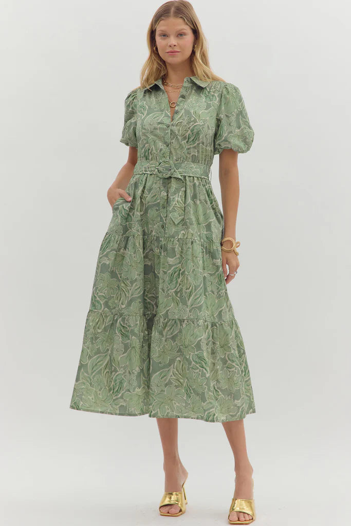 Woman wearing a green patterned dress on a white background