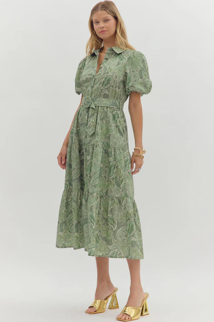 Woman wearing a green patterned dress on a white background