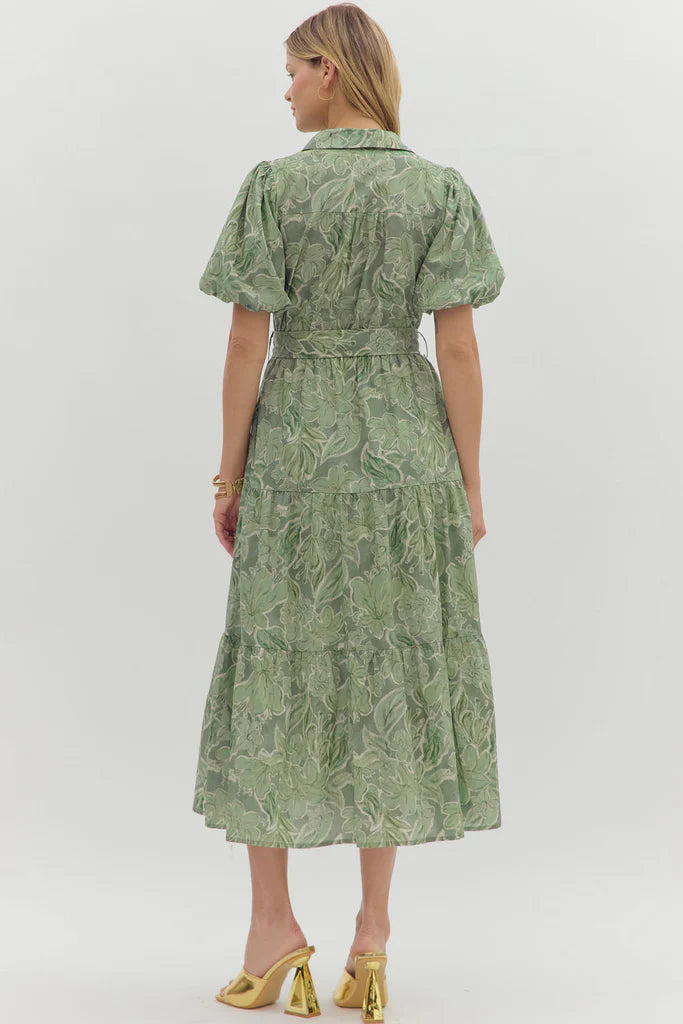 Woman wearing a green patterned dress on a white background