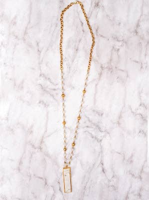 White marble rectangle pendant on a white crystal and gold beaded necklace.